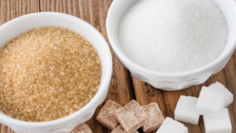 Brown sugar and white sugar in a bowl against wooden table background