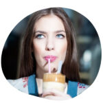 A woman drinking iced coffee using a straw