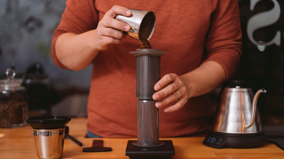 A man doing espresso coffee with help of Aeropress coffee maker