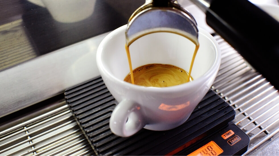 Double-espresso being poured by a powerful coffee machine