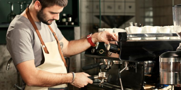 Barista preparing a shot of espresso that will end up in a demitasse cup