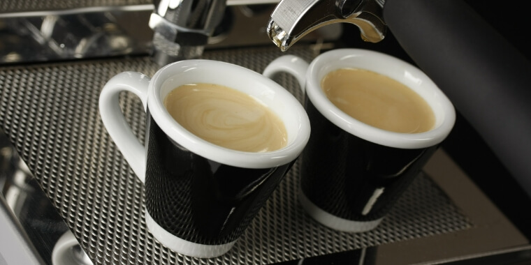 An espresso cup filled with freshly brewed espresso and foamy creama on the top